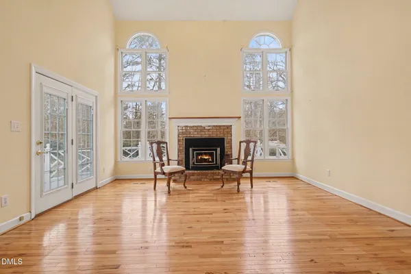 a view of a livingroom with furniture wooden floor windows and a fireplace