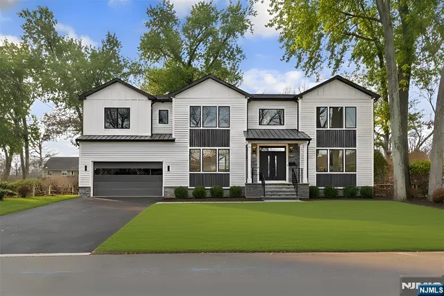a front view of a house with a yard and trees