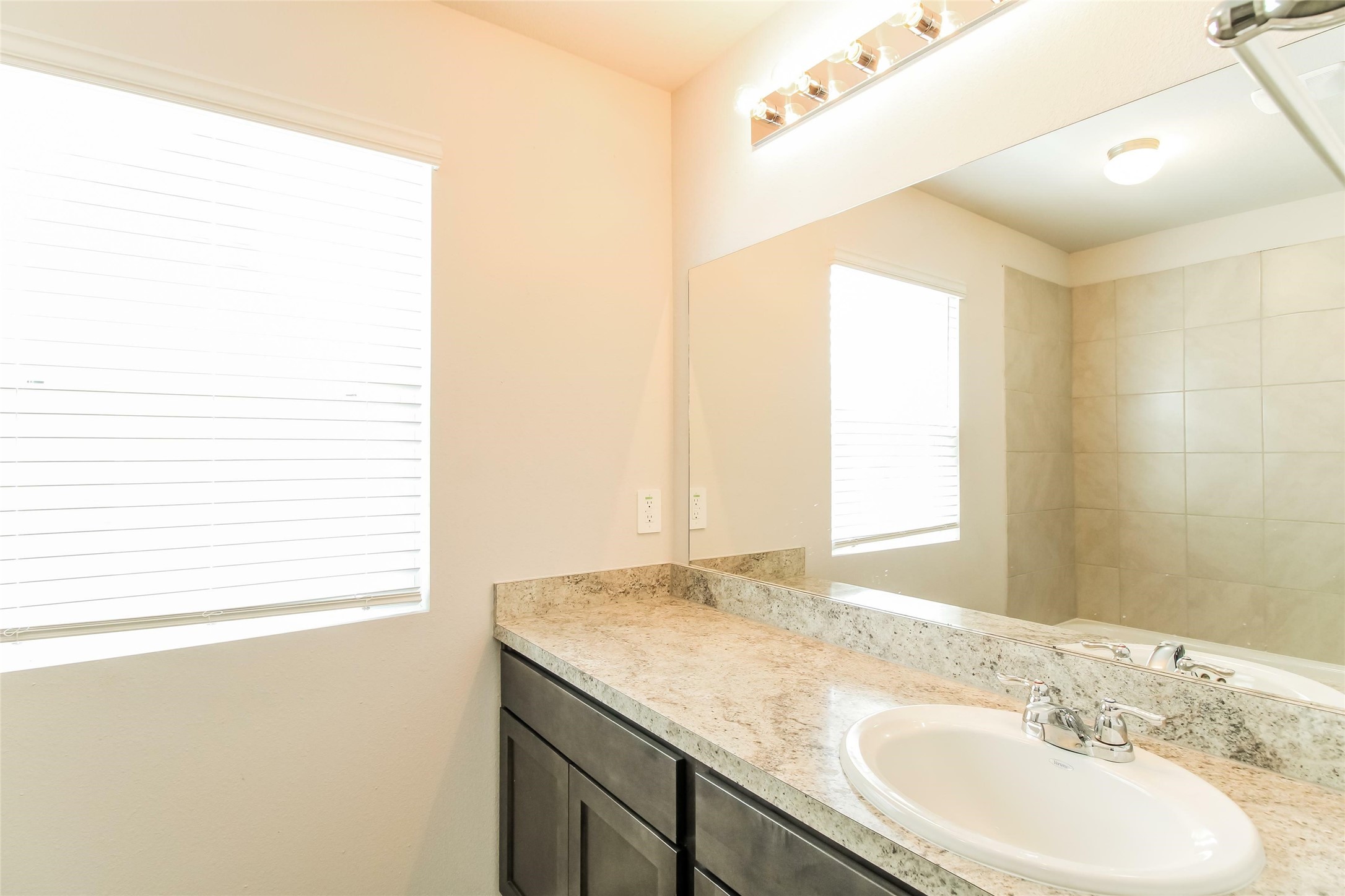 2529 Grayling Drive Conroe, TX 77384 - Photo 6 of 18 a bathroom with a granite countertop sink and a mirror