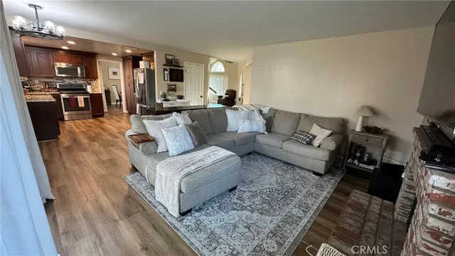 a living room with furniture and view of kitchen