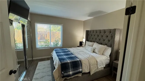 a bedroom with a bed a mirror and a window