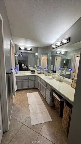 a large kitchen with a large counter top space a sink stainless steel appliances and cabinets