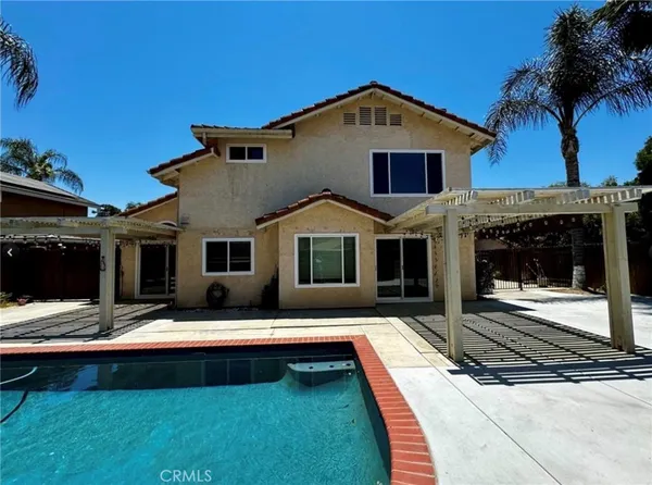 a front view of a house with yard and swimming pool