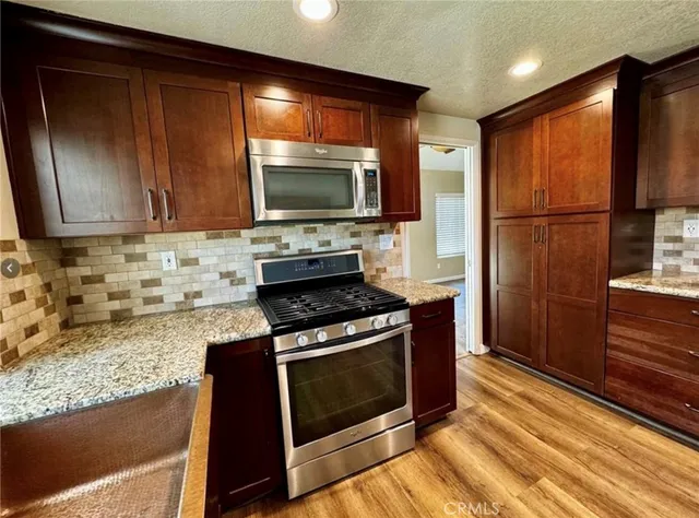 a kitchen with wooden cabinets and a stove top oven