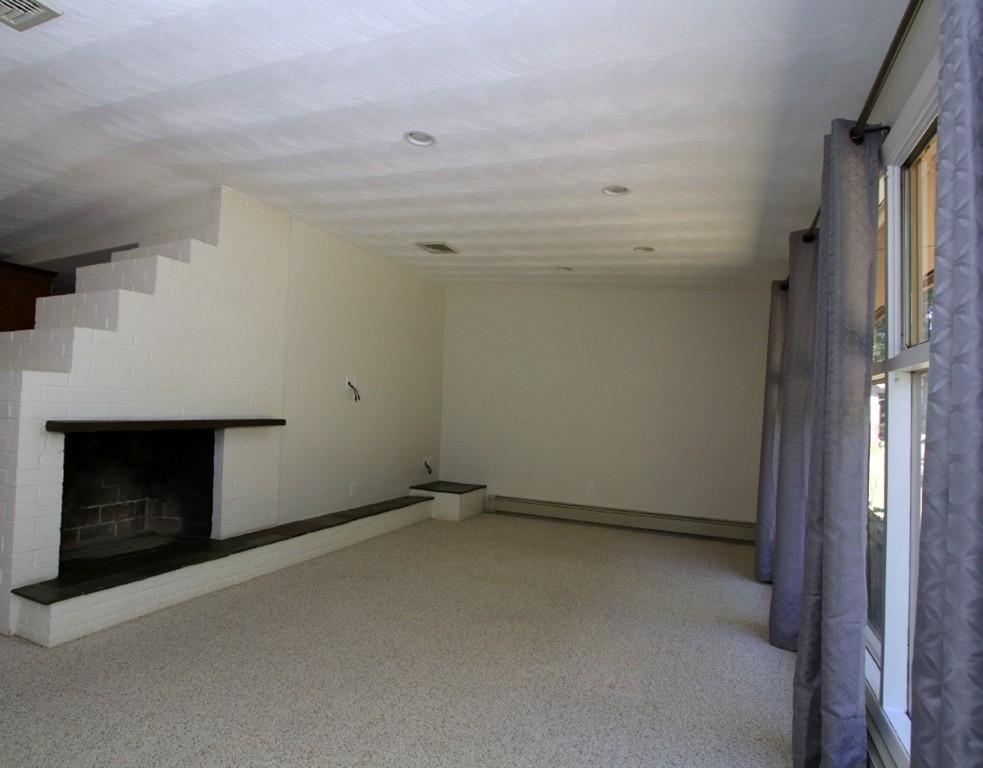 15 Temi Road Framingham, MA 01701 - Photo 10 of 13 a view of an empty room with a fireplace and a window