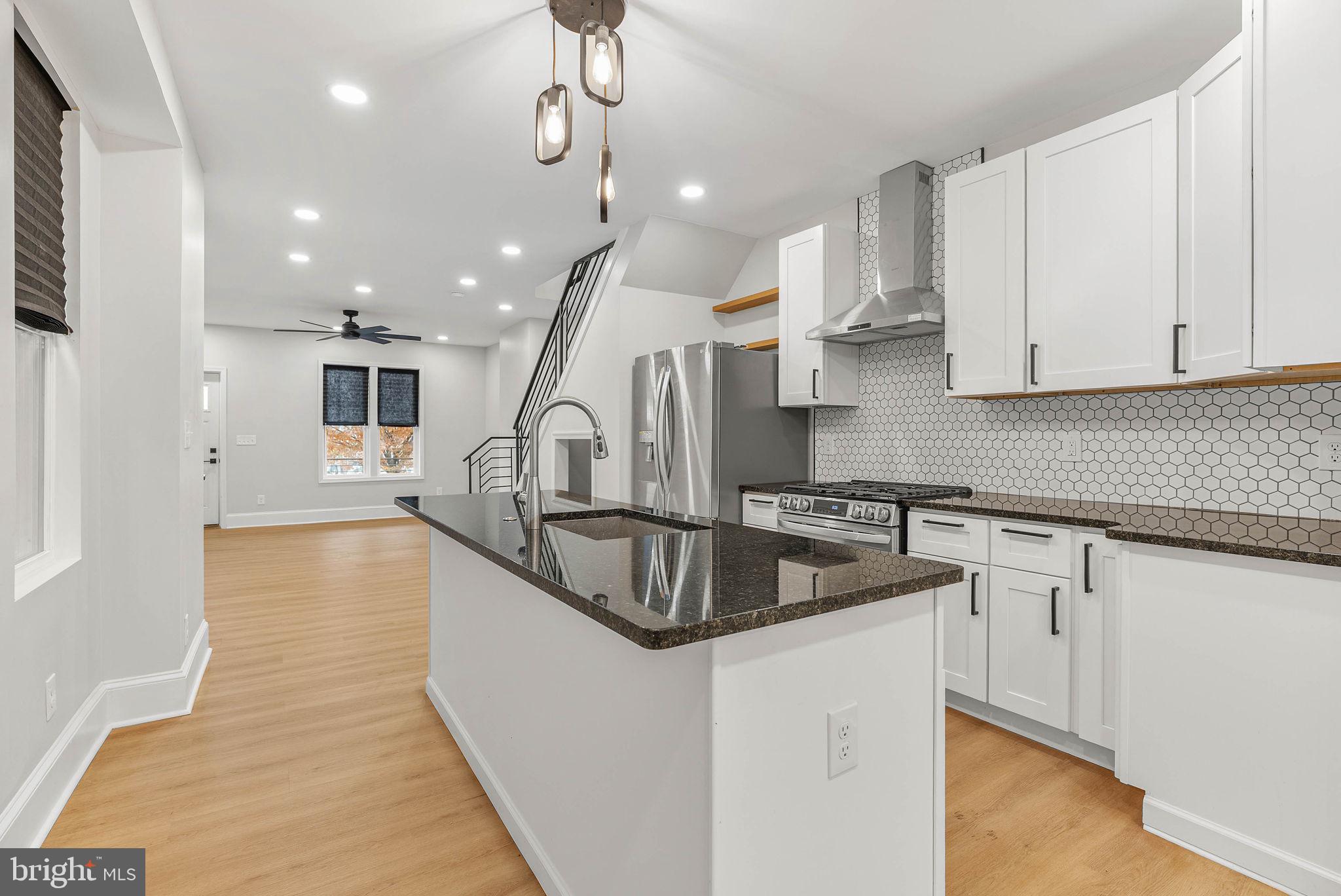 5737 Springfield Avenue Philadelphia, PA 19143 - Photo 13 of 31 a kitchen with stainless steel appliances granite countertop a sink a stove and a refrigerator
