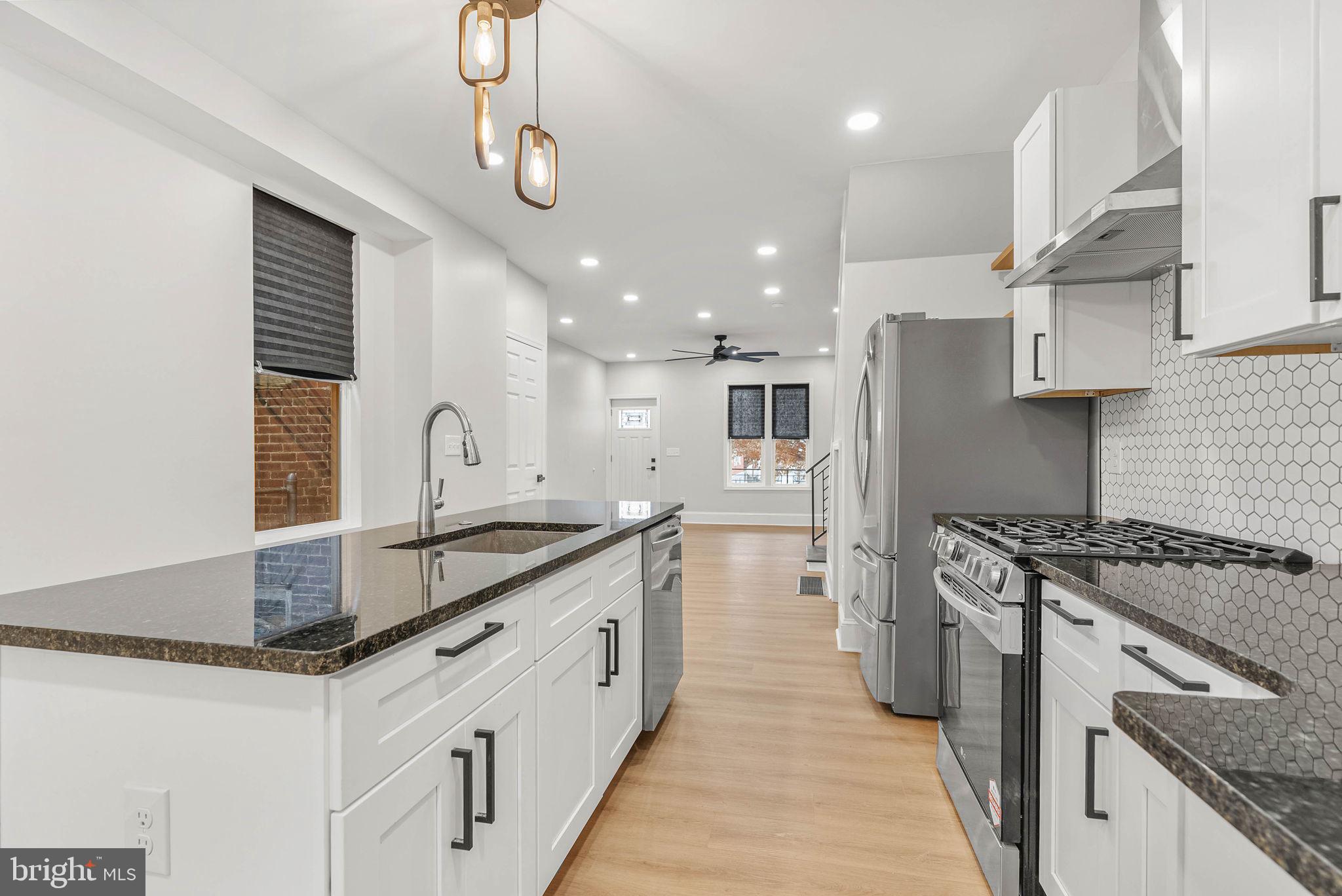 5737 Springfield Avenue Philadelphia, PA 19143 - Photo 14 of 31 a kitchen with stainless steel appliances granite countertop a sink stove and refrigerator