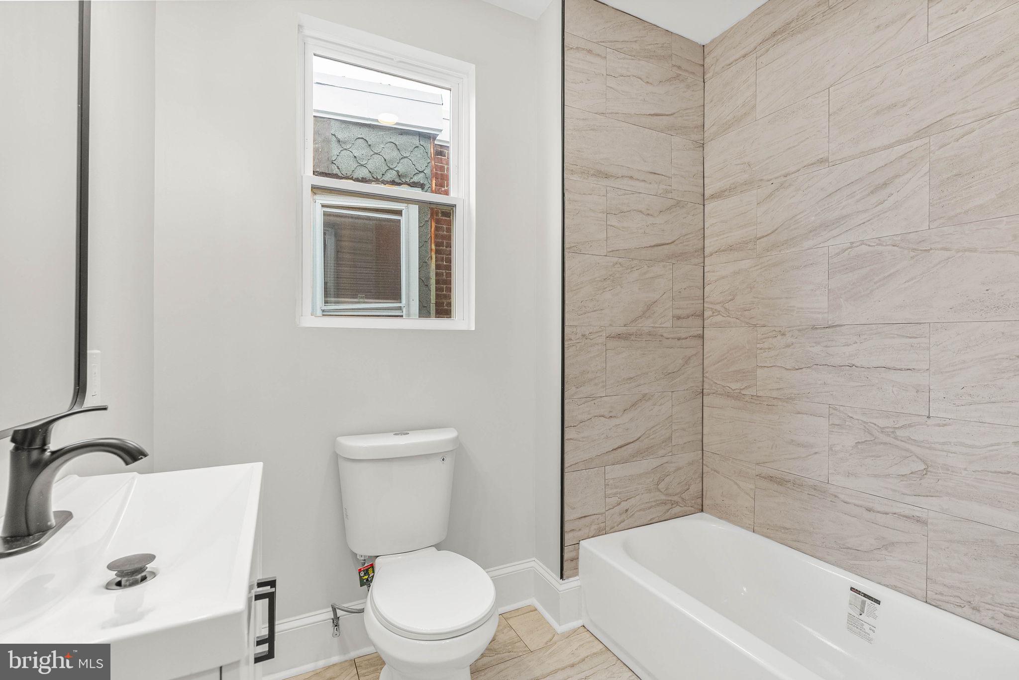 5737 Springfield Avenue Philadelphia, PA 19143 - Photo 28 of 31 a white toilet sitting next to a bath tub