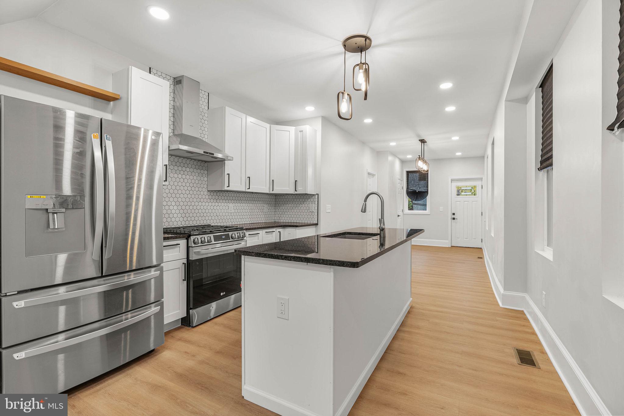 5737 Springfield Avenue Philadelphia, PA 19143 - Photo 9 of 31 a large kitchen with stainless steel appliances and a refrigerator
