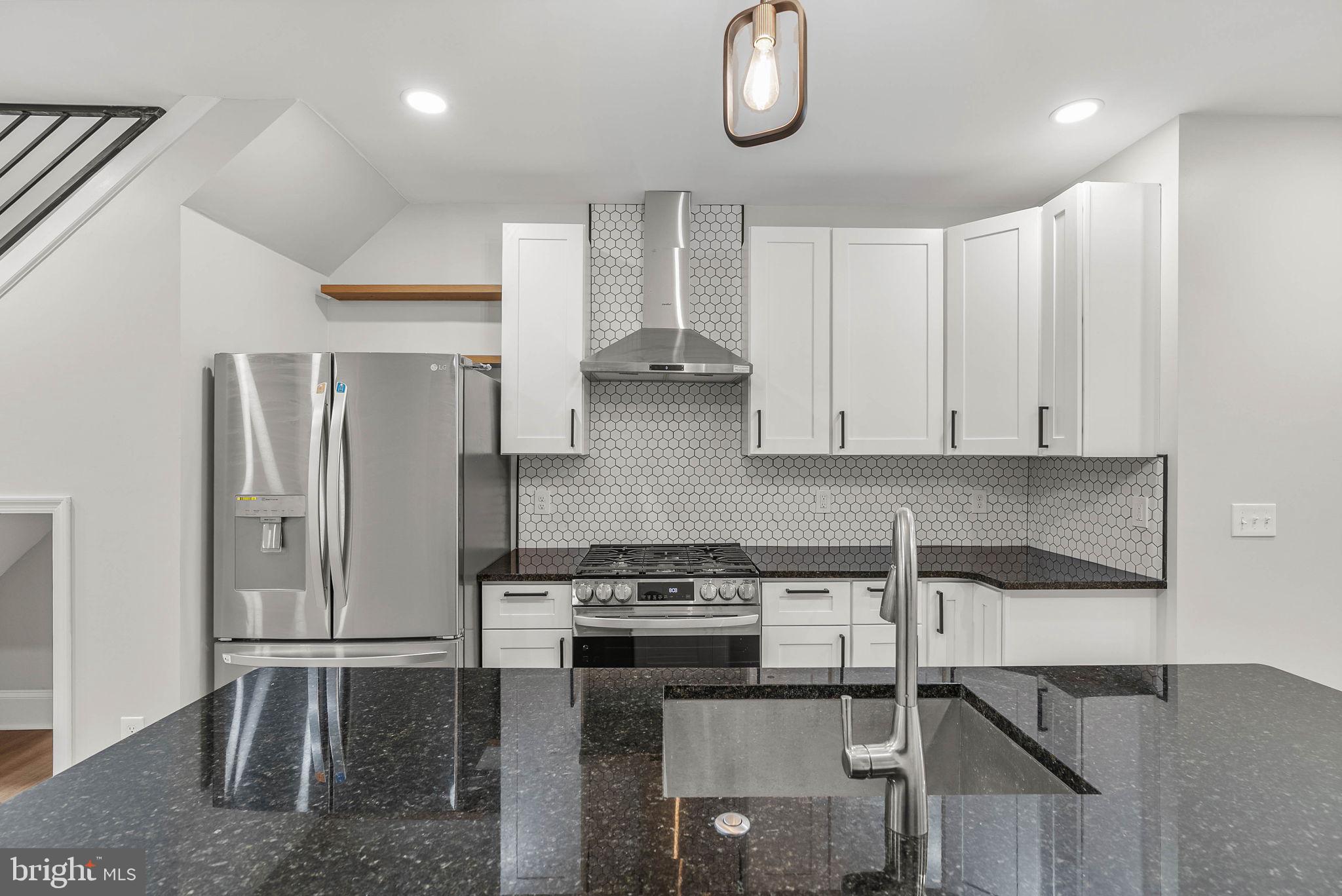 5737 Springfield Avenue Philadelphia, PA 19143 - Photo 10 of 31 a kitchen with stainless steel appliances granite countertop a stove a refrigerator and a cabinets