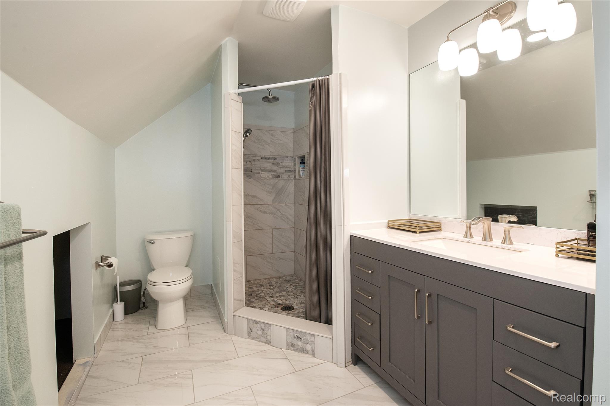 22 Cloverport Avenue Rochester, MI 48307 - Photo 18 of 48 Primary Bathroom with Dark Vanity Cabinetry, Quartz Countertop, and Chrome Fixtures
This spa-inspired bathroom features a charcoal-finish vanity with ample storage and drawer space, topped with a white quartz countertop and polished chrome faucet
