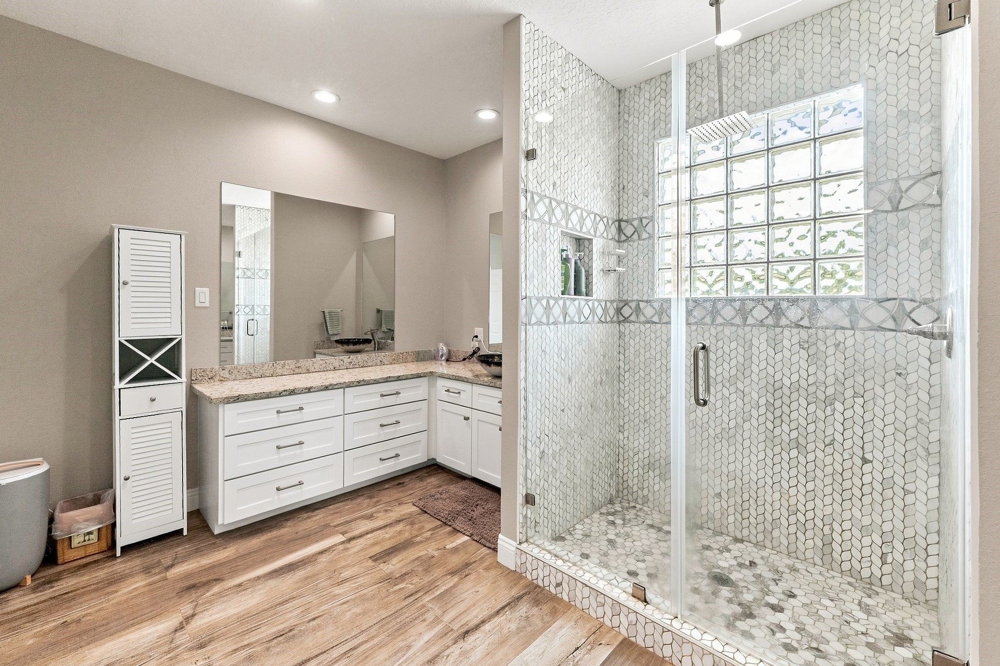 9010 Point Barrow Road Beach City, TX 77523 - Photo 20 of 50 The oversized walk-in shower becomes the focal point from this angle, wrapped in detailed tilework with a glass enclosure, rainfall showerhead & glass-block window bringing natural light into the space.