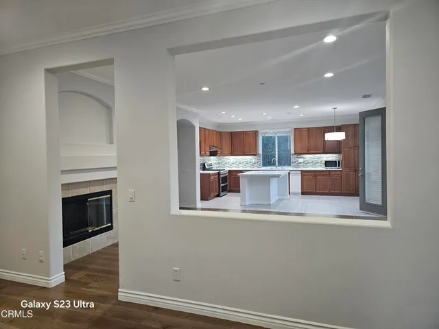 a view of a kitchen with a sink and an empty room