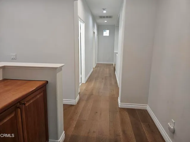 a view of a hallway with wooden floor