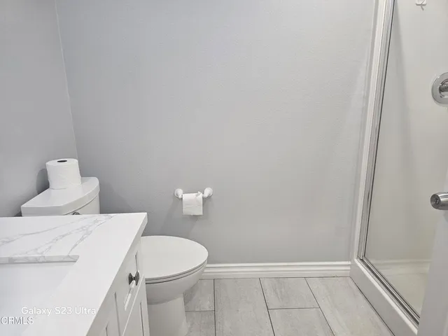 a white toilet sitting next to a shower