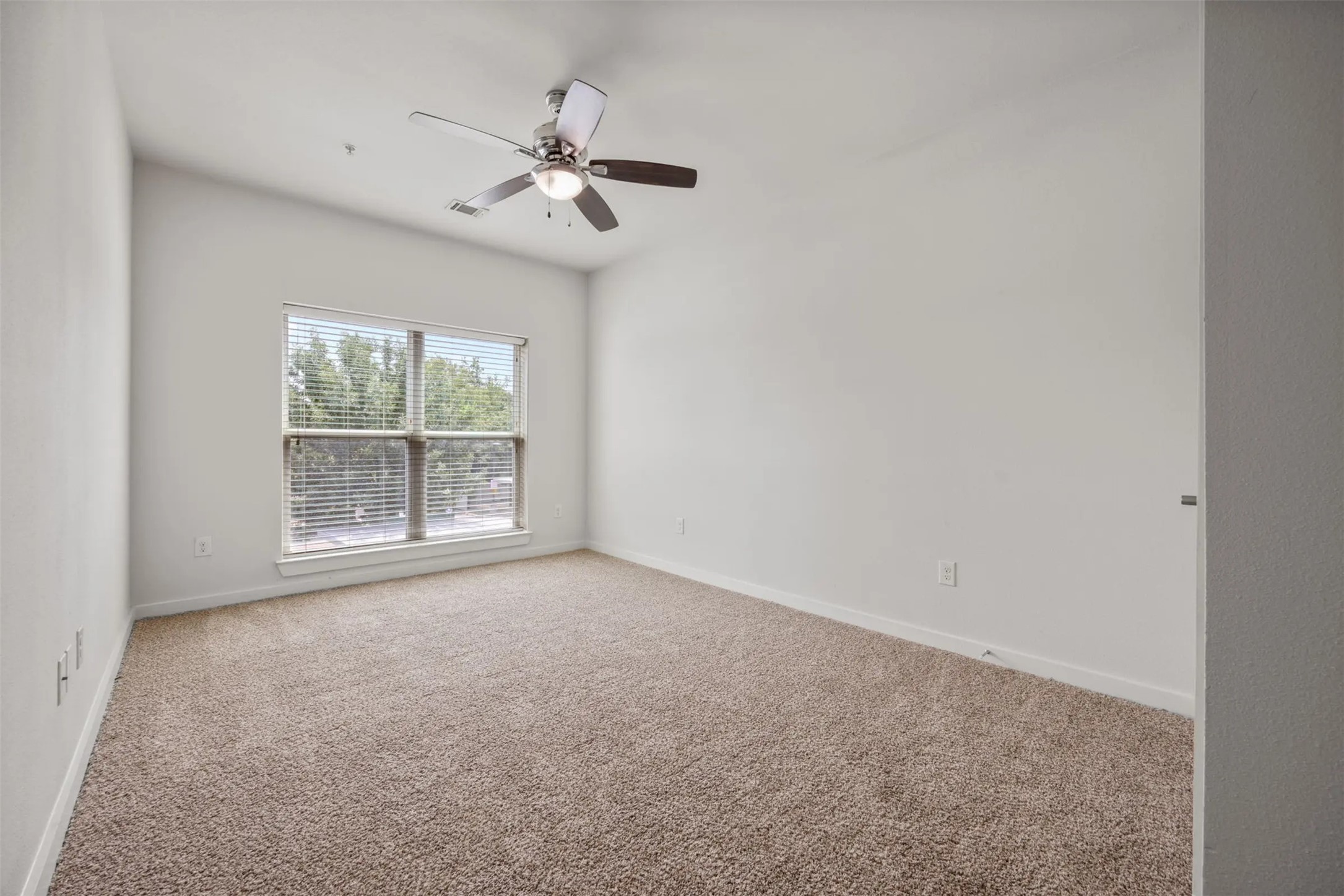 6725 Circle S Road, Unit B1257 Austin, TX 78745 - Photo 13 of 23 en empty room with windows and chandelier fan