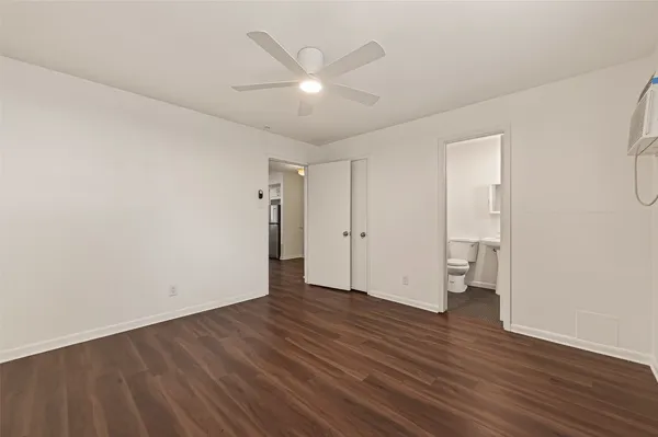 a view of an empty room with wooden floor