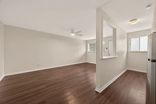 a view of an empty room with closet and wooden floor
