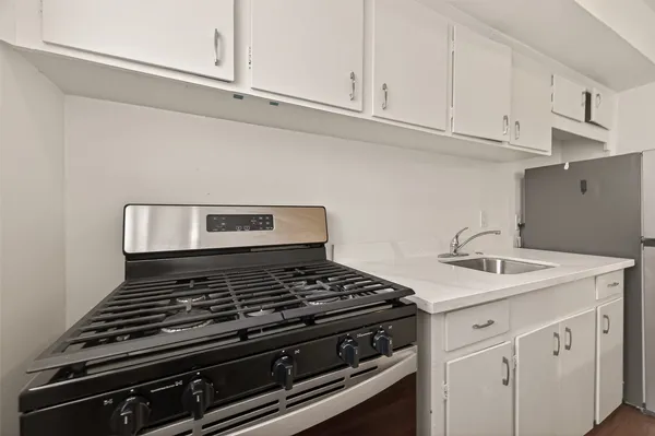 a kitchen with stainless steel appliances granite countertop a sink and a wooden floor