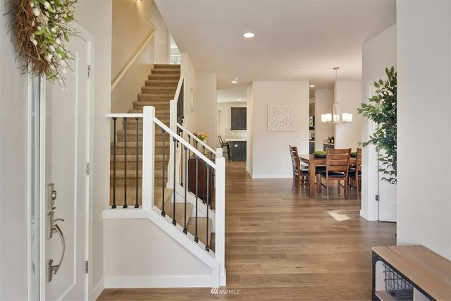 a view of a hallway with dining room and stairs