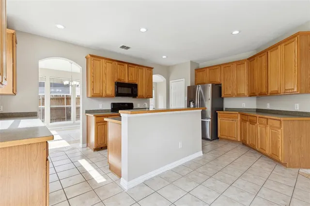 a kitchen with stainless steel appliances granite countertop a stove a sink dishwasher a refrigerator and a microwave