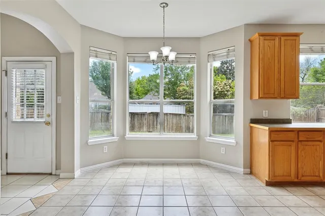 a view of an empty room with window and cabinet
