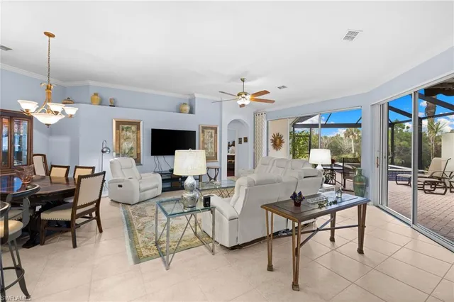 a living room with furniture kitchen view and a chandelier