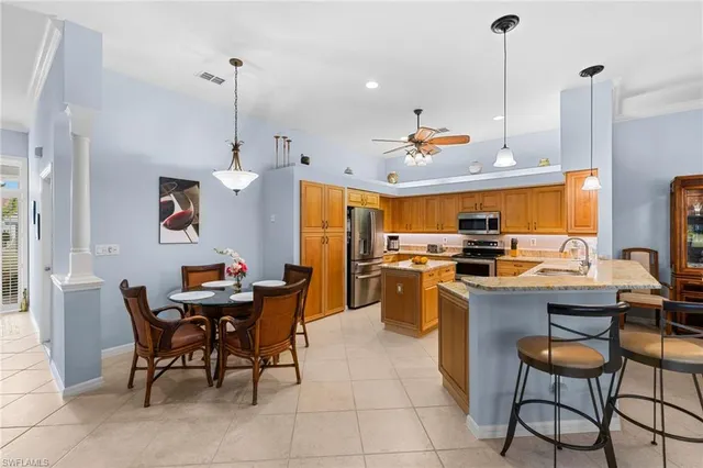 a kitchen with a sink a stove and chairs