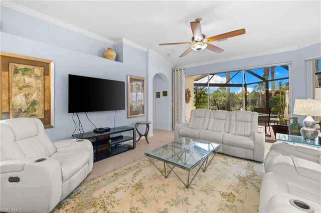 a living room with furniture a chandelier and a flat screen tv