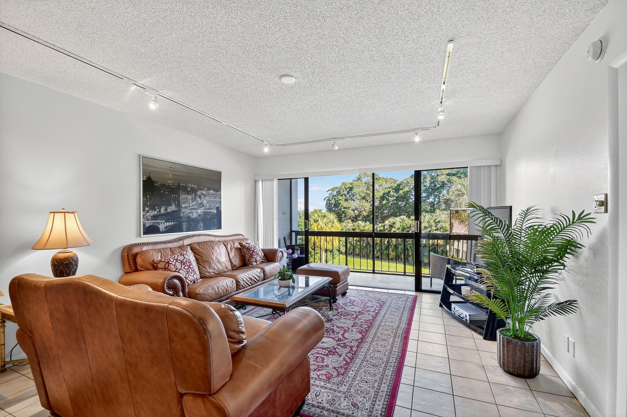 2500 Presidential Way, Unit 302 West Palm Beach, FL 33401 - Photo 14 of 52 a living room with furniture potted plant and a large window