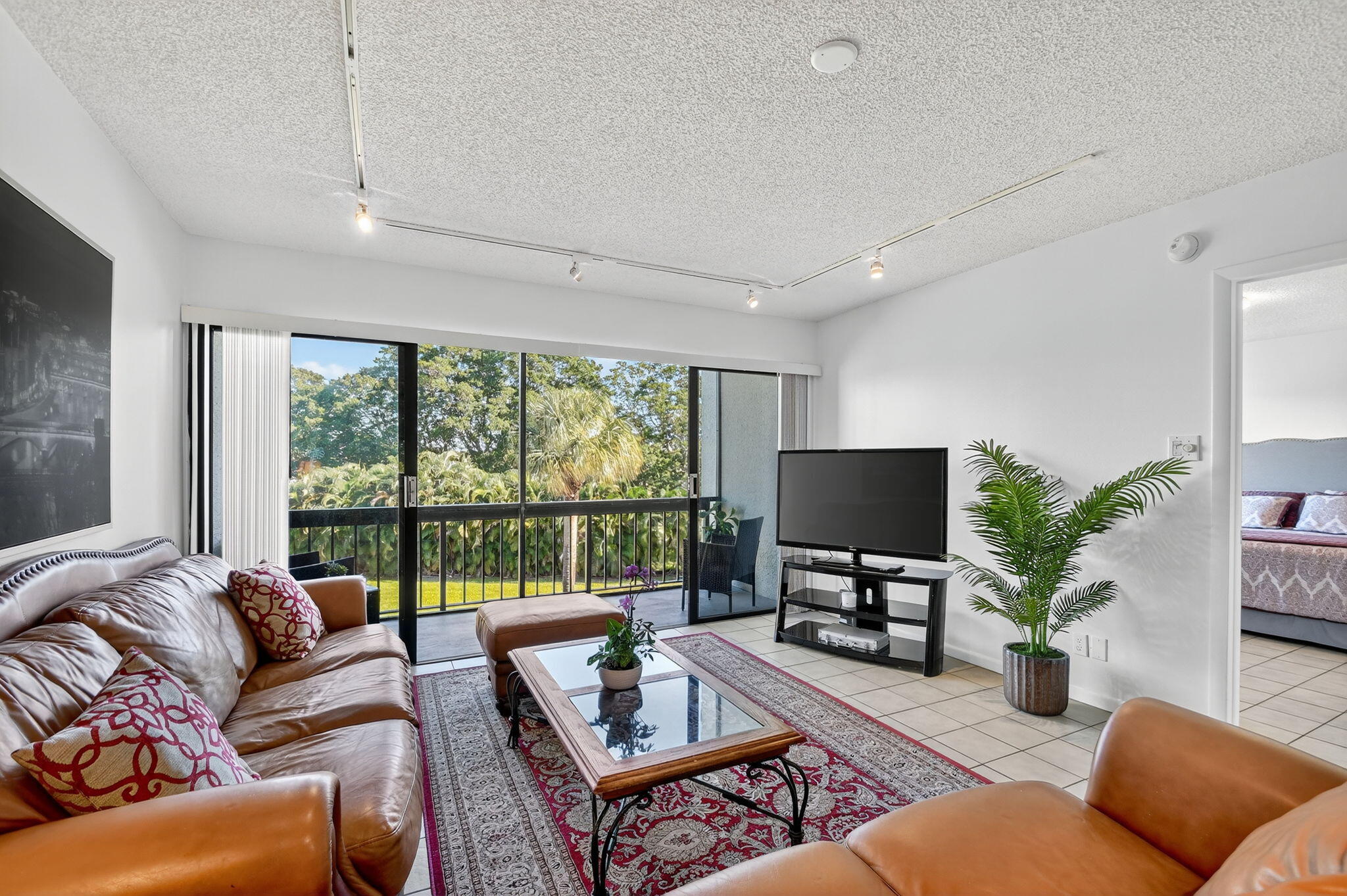 2500 Presidential Way, Unit 302 West Palm Beach, FL 33401 - Photo 15 of 52 a living room with furniture and a flat screen tv