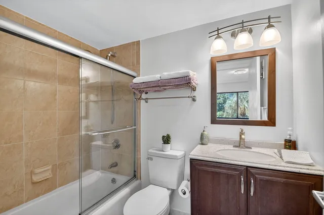 a bathroom with a granite countertop sink toilet and shower