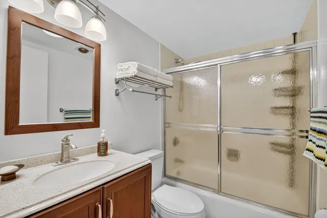 a bathroom with a sink a toilet and shower