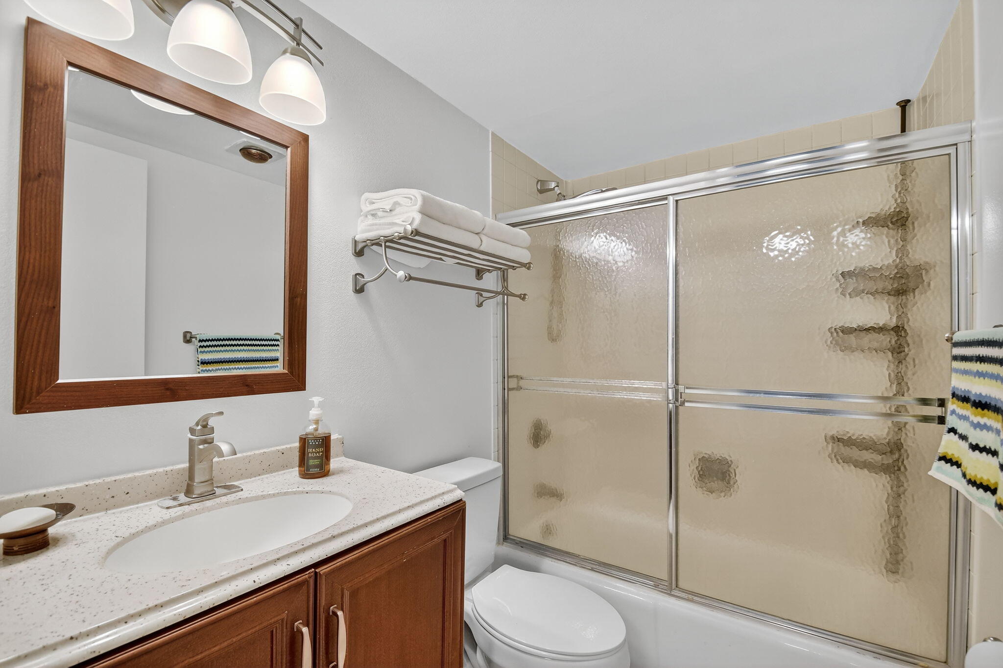 2500 Presidential Way, Unit 302 West Palm Beach, FL 33401 - Photo 33 of 52 a bathroom with a shower sink vanity mirror and toilet