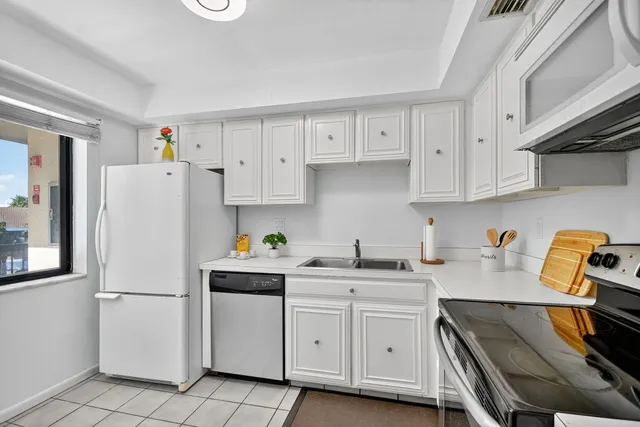 a kitchen with white cabinets and white appliances