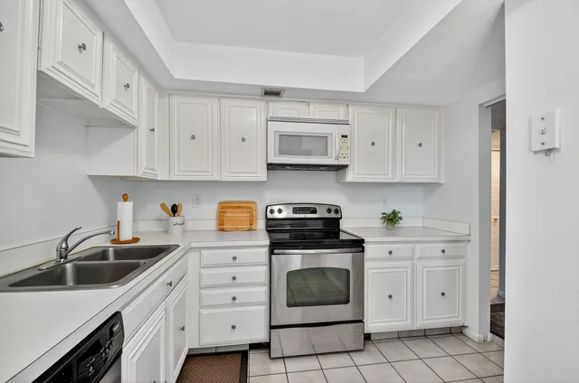 a kitchen with cabinets stainless steel appliances and a sink