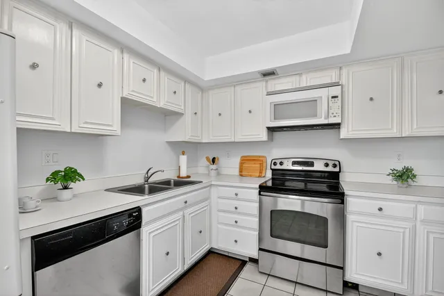 a kitchen with white cabinets and white appliances
