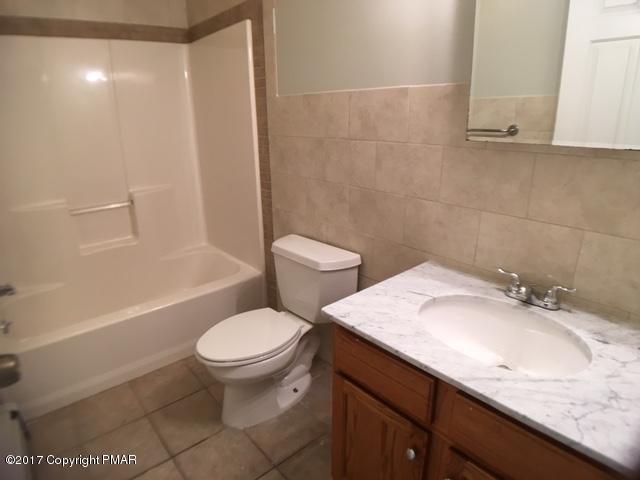 137 Ryan Road Blakeslee, PA 18610 - Photo 8 of 13 a bathroom with a granite countertop sink a toilet a mirror and shower