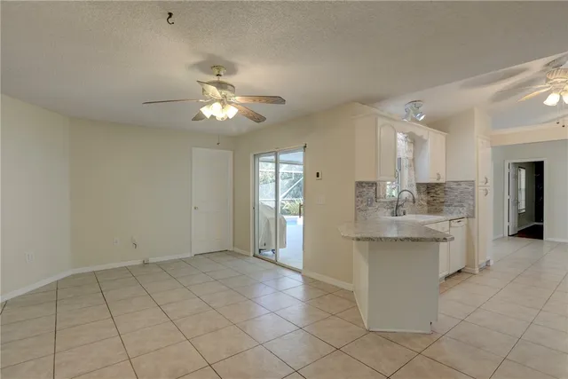 a view of kitchen with granite countertop cabinets a sink and a chandelier