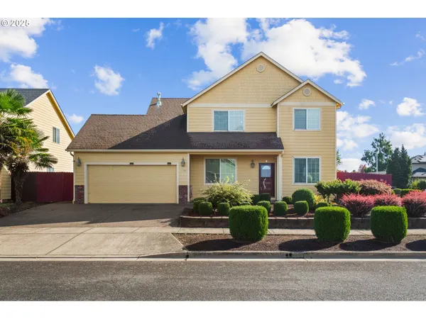 a front view of a house with a yard and potted plants