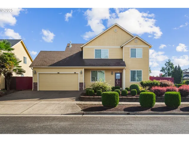 a front view of a house with a yard and potted plants