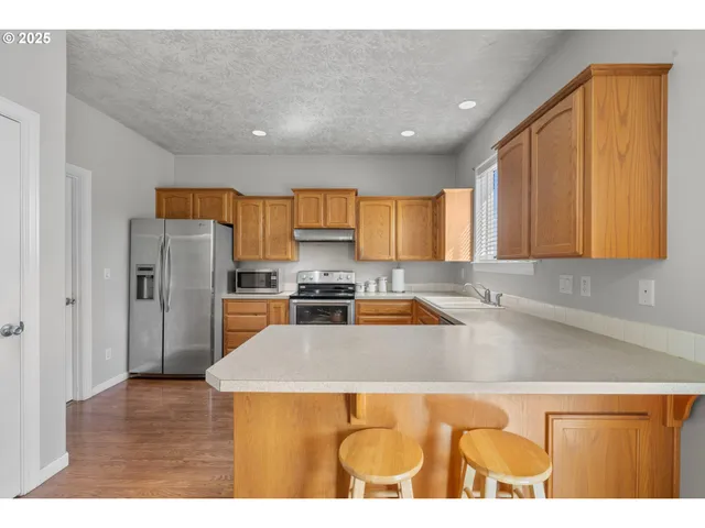 a kitchen with stainless steel appliances granite countertop a refrigerator a sink and a stove