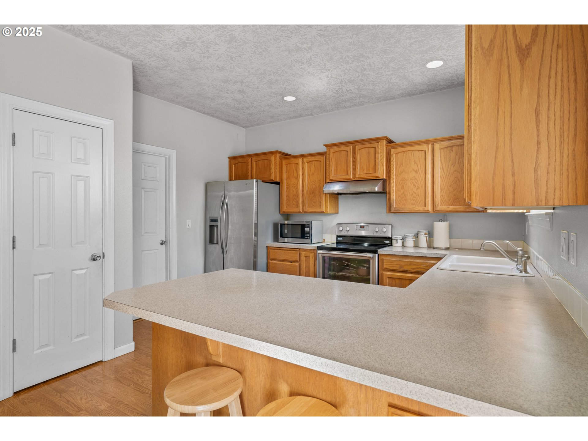 4199 Geranium Loop Northeast Salem, OR 97305 - Photo 12 of 43 a kitchen with stainless steel appliances granite countertop a refrigerator sink and cabinets