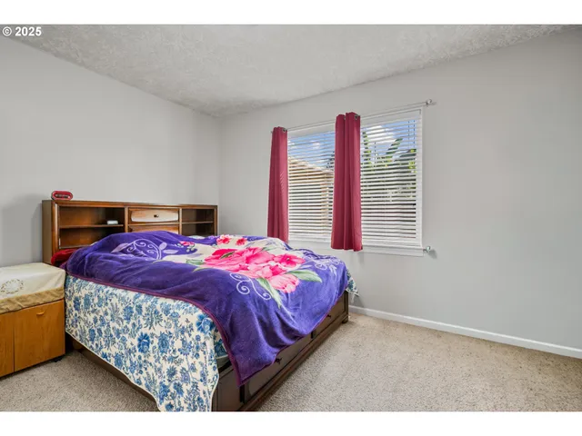 a bedroom with a bed and a large window