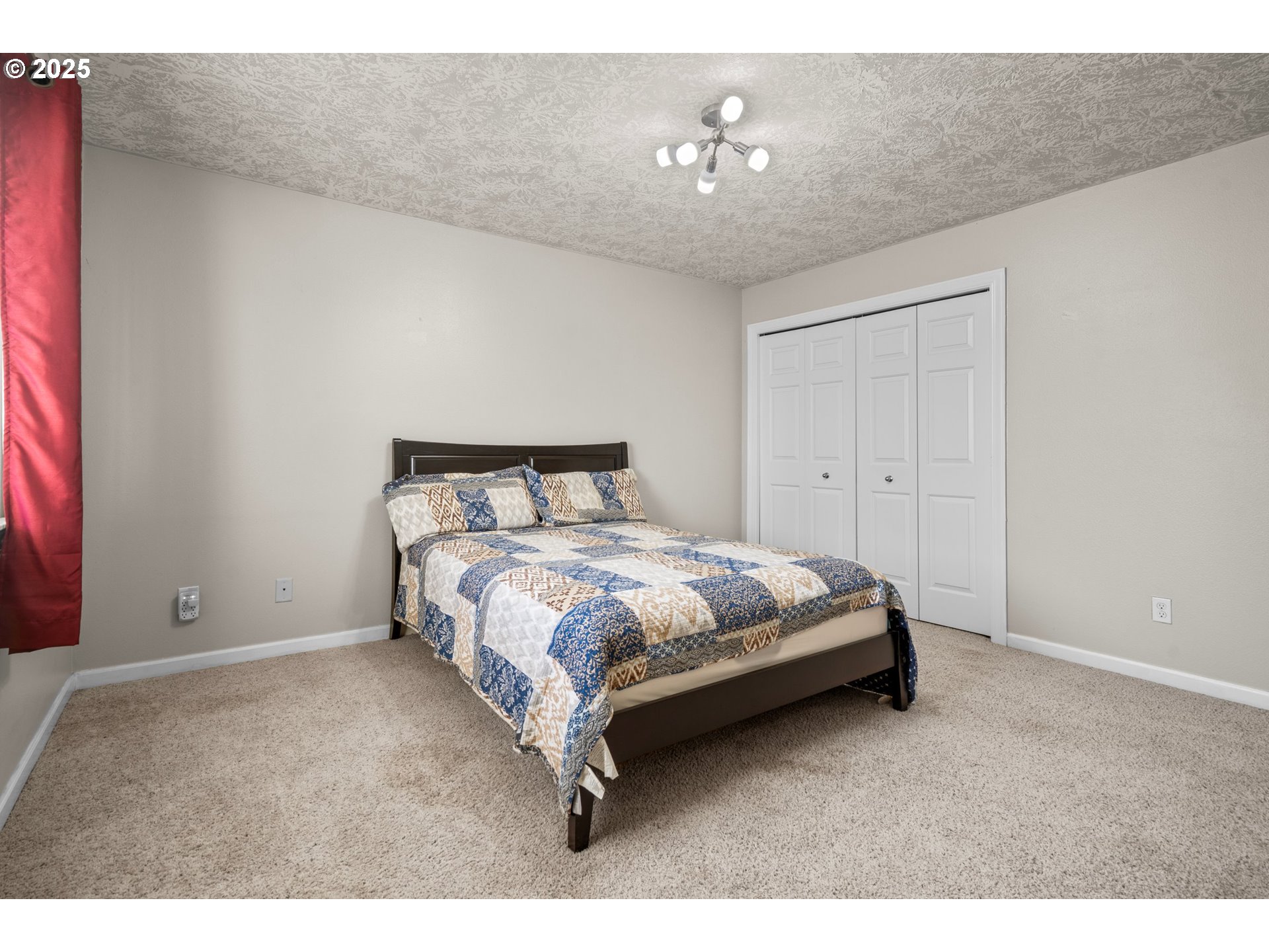 4199 Geranium Loop Northeast Salem, OR 97305 - Photo 24 of 43 a spacious bedroom with a bed and lamp