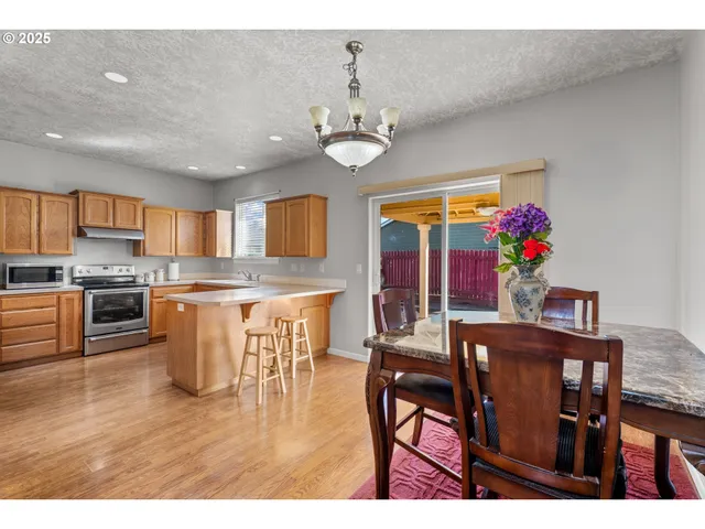 a view of a dining room with furniture a chandelier and wooden floor