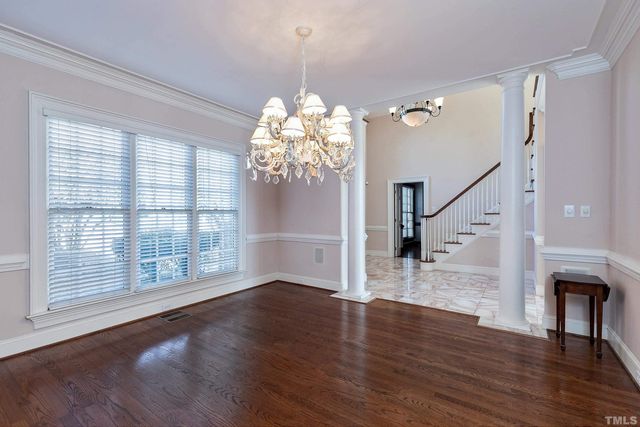a view of an room with wooden floor chandelier and windows
