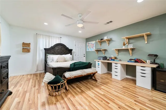 a living room with stainless steel appliances furniture and a wooden floor