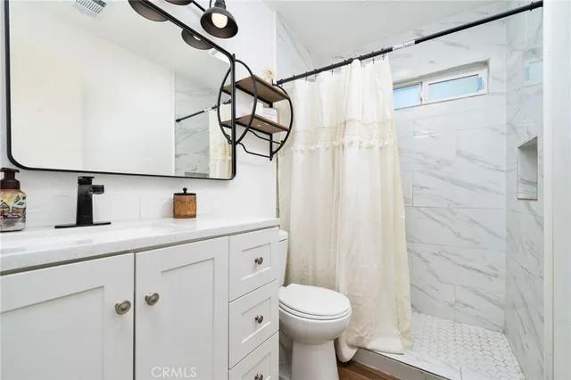 a bathroom with a sink a toilet and shower