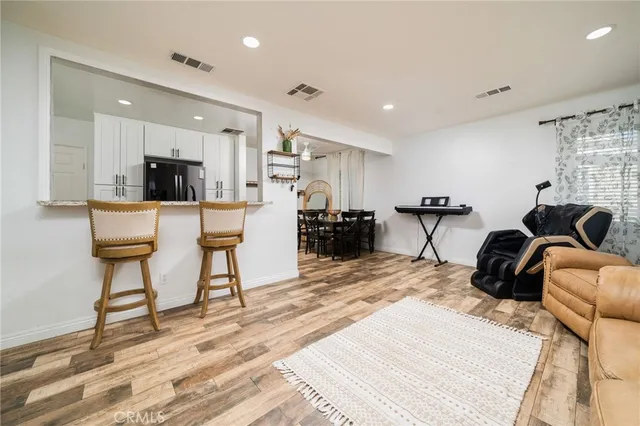 a living room kitchen with furniture and a wooden floor